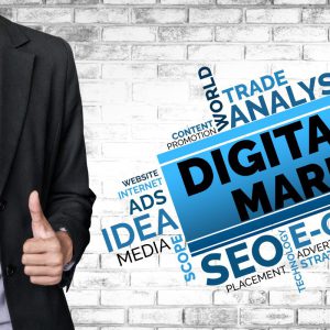 Digital marketing concept showing a businessman with thumbs up alongside keywords like SEO, ads, media, and online strategy on a brick wall background.
